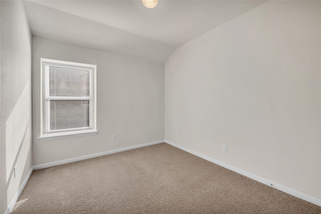 carpeted empty room with lofted ceiling