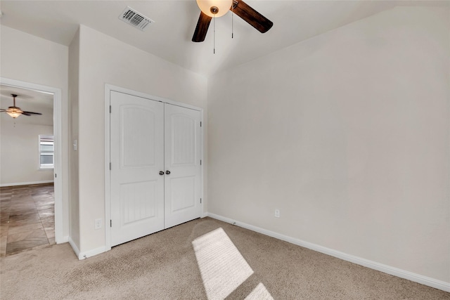 unfurnished bedroom with ceiling fan, a closet, and light carpet