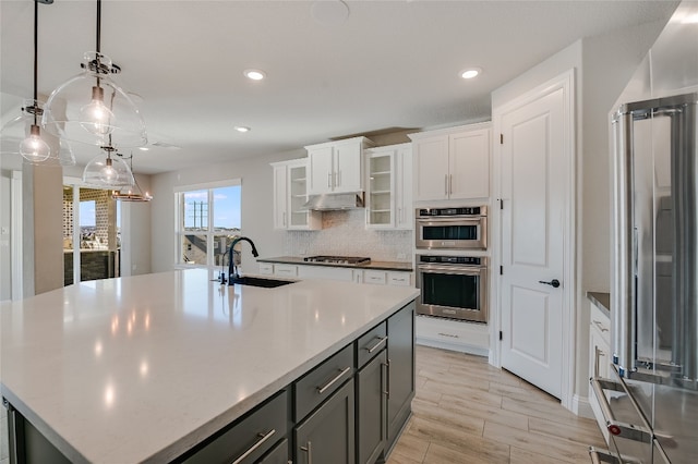 125 Serene Hilltop Cir, Austin, TX 78738 - kitchen with appliances with stainless steel finishes, a sink, an island with sink, white cabinetry, and recessed lighting