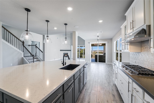 125 Serene Hilltop Cir, Austin, TX 78738 - kitchen with a sink, appliances with stainless steel finishes, under cabinet range hood, backsplash, and recessed lighting