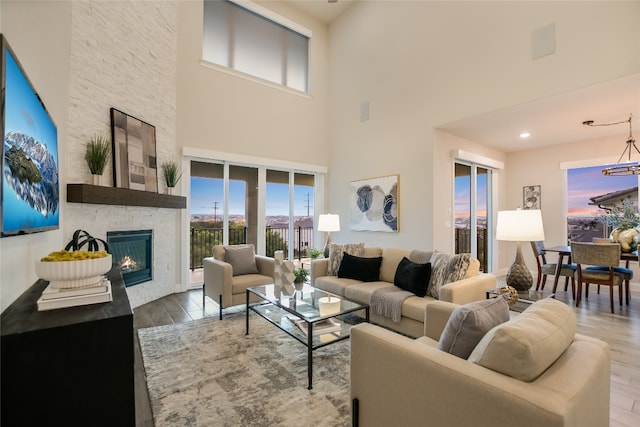 125 Serene Hilltop Cir, Austin, TX 78738 - living room with plenty of natural light, wood finished floors, a chandelier, a fireplace, and a high ceiling