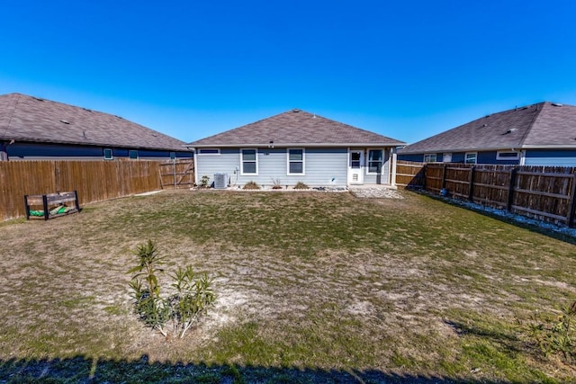 back of property with a yard and central AC unit