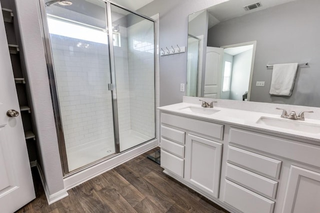 bathroom featuring hardwood / wood-style flooring, vanity, and walk in shower