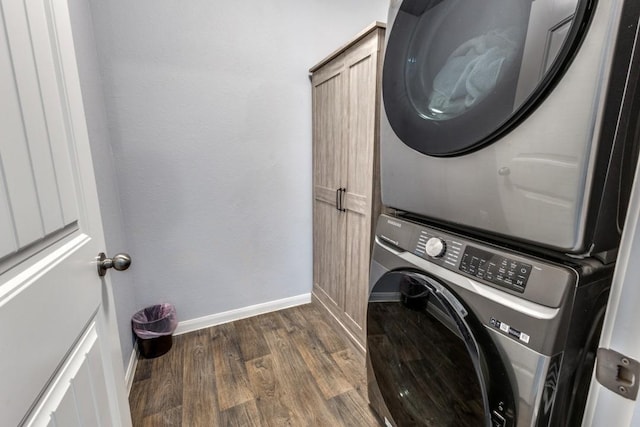 laundry area with stacked washer and dryer and dark hardwood / wood-style floors