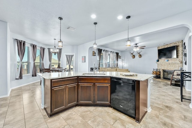 kitchen featuring dishwasher, pendant lighting, a kitchen island with sink, and sink