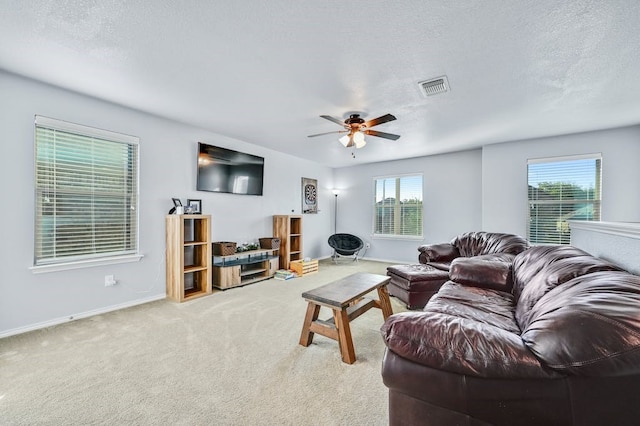 living room with plenty of natural light, light carpet, a textured ceiling, and ceiling fan