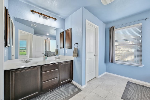 1712 Uhland Dr, Leander, TX 78641 - bathroom with double vanity, tile patterned flooring, healthy amount of natural light, and a shower