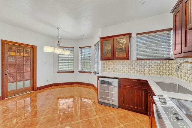 kitchen with wine cooler, sink, decorative backsplash, and stove