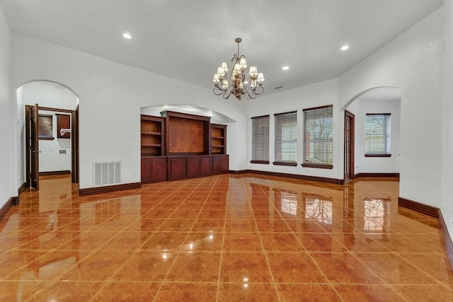 unfurnished room with a chandelier