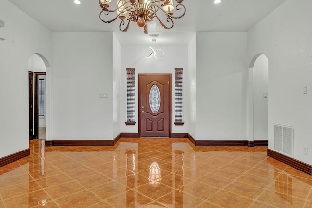 foyer featuring an inviting chandelier and a high ceiling