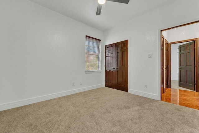 unfurnished bedroom with ceiling fan, a closet, and light carpet