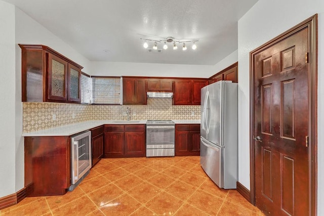 kitchen featuring stainless steel appliances, beverage cooler, sink, and backsplash