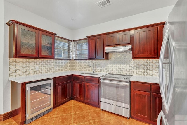 kitchen featuring sink, appliances with stainless steel finishes, backsplash, wine cooler, and light tile patterned flooring