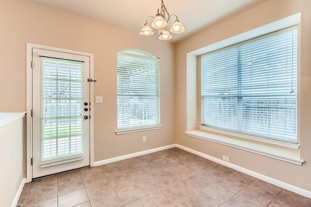 doorway with light tile patterned floors and a chandelier