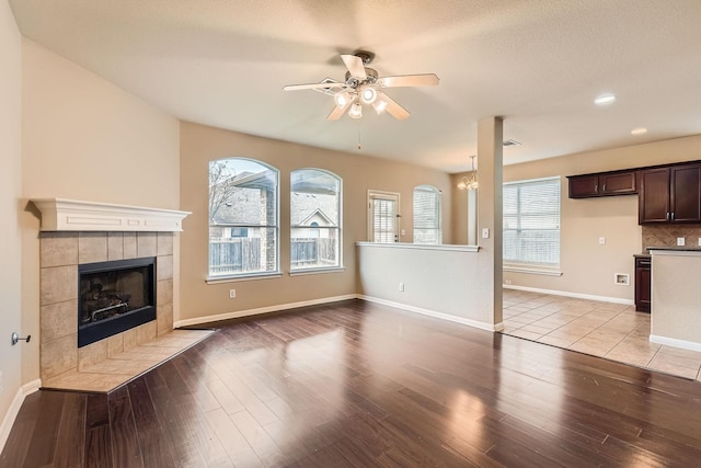 unfurnished living room with ceiling fan, light wood-type flooring, and a fireplace