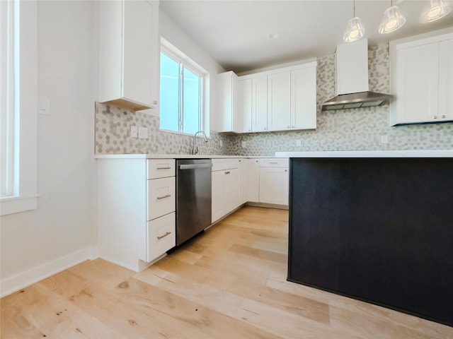 kitchen featuring white cabinetry, wall chimney range hood, stainless steel dishwasher, and hanging light fixtures