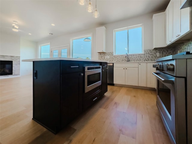 kitchen featuring appliances with stainless steel finishes, white cabinets, and decorative backsplash