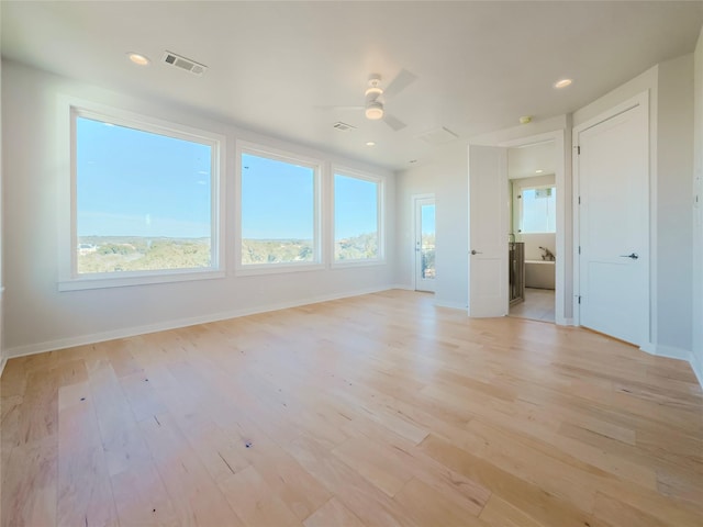 spare room featuring ceiling fan and light hardwood / wood-style flooring