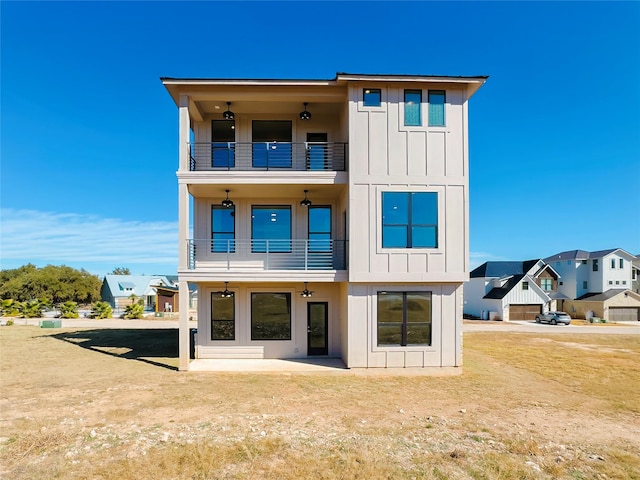 rear view of property with a balcony and a lawn