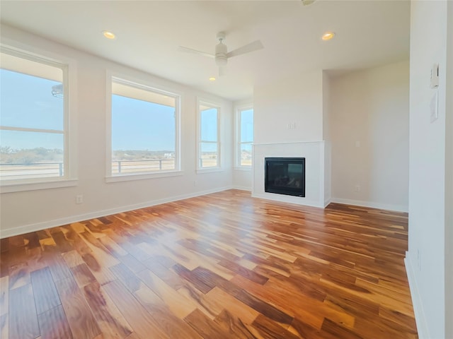 unfurnished living room featuring ceiling fan and wood-type flooring