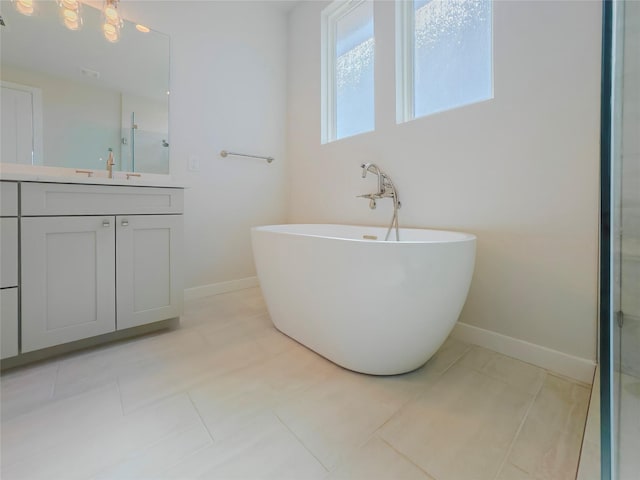 bathroom with vanity, a tub, and tile patterned floors