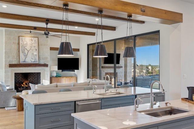 kitchen featuring decorative light fixtures, light stone countertops, and sink