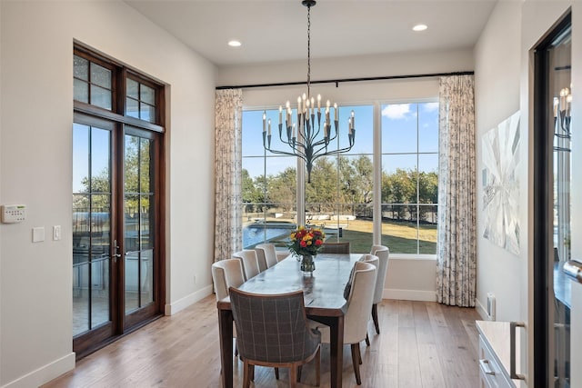 dining area with an inviting chandelier and light wood-type flooring