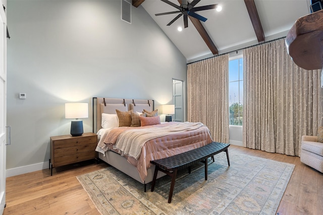 bedroom with beamed ceiling, ceiling fan, and light wood-type flooring