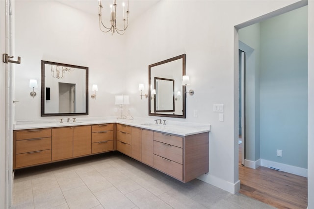 bathroom featuring an inviting chandelier, tile patterned floors, and vanity