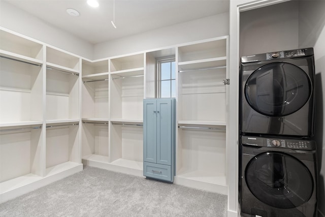 washroom featuring stacked washer / dryer and light carpet