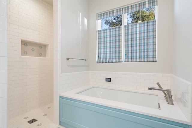 bathroom featuring separate shower and tub and tile walls