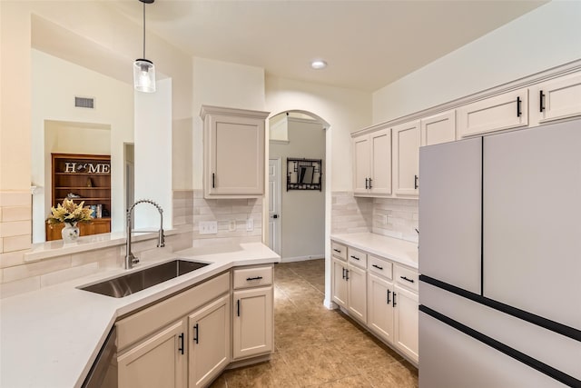 kitchen featuring tasteful backsplash, white refrigerator, sink, and pendant lighting