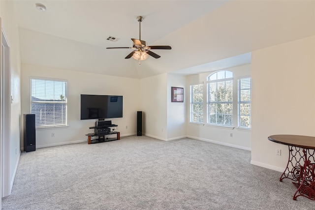 unfurnished living room with a wealth of natural light, lofted ceiling, and light carpet