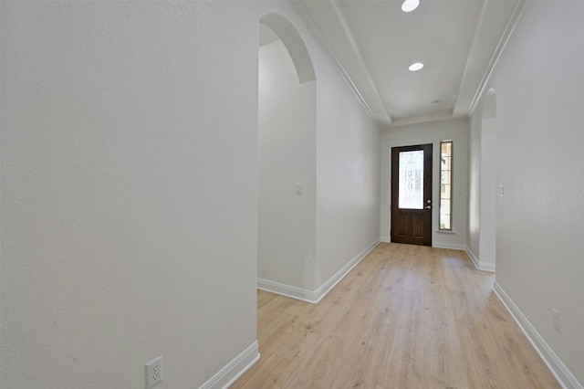 entryway with ornamental molding and light hardwood / wood-style floors