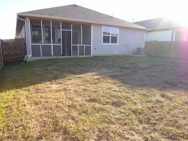 back of house with a yard, central AC, and a sunroom