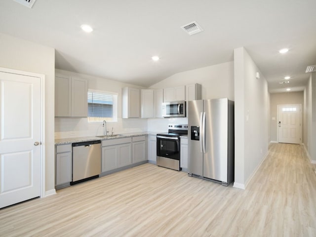 kitchen with a sink, visible vents, appliances with stainless steel finishes, light wood-type flooring, and gray cabinets