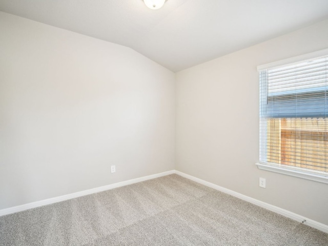 spare room with lofted ceiling, carpet flooring, and baseboards