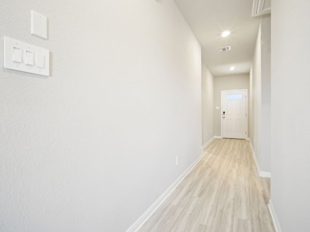 corridor featuring light wood-style flooring, visible vents, baseboards, and recessed lighting