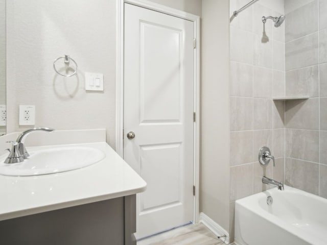 bathroom featuring  shower combination, wood finished floors, and vanity