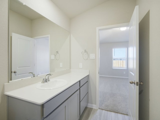 bathroom with vanity, baseboards, and wood finished floors