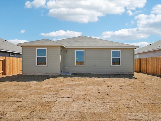 rear view of property featuring a fenced backyard