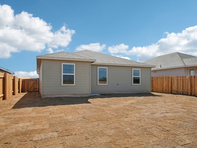 rear view of property featuring a fenced backyard