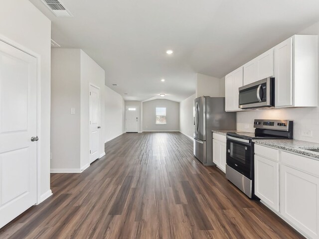 249 Boatright Blvd, Jarrell, TX 76537 - kitchen with stainless steel appliances, white cabinetry, dark wood-type flooring, recessed lighting, and vaulted ceiling