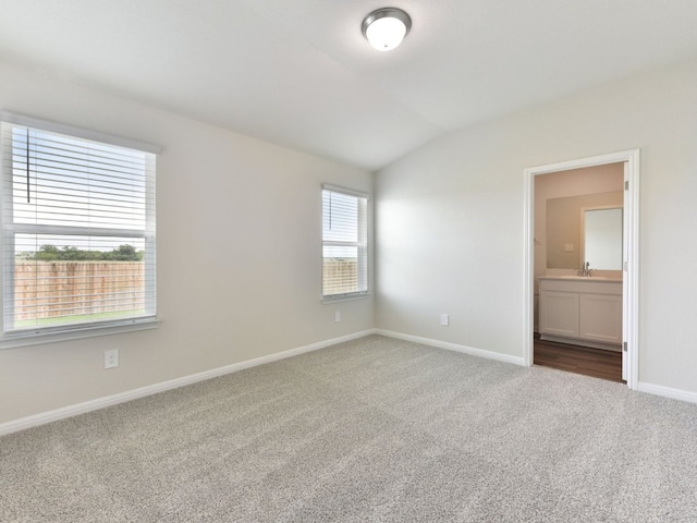 249 Boatright Blvd, Jarrell, TX 76537 - unfurnished bedroom featuring carpet flooring, vaulted ceiling, baseboards, ensuite bath, and a sink