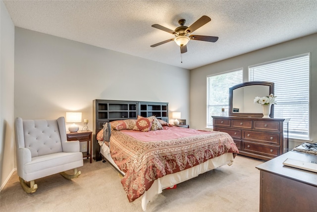 carpeted bedroom featuring a textured ceiling and ceiling fan