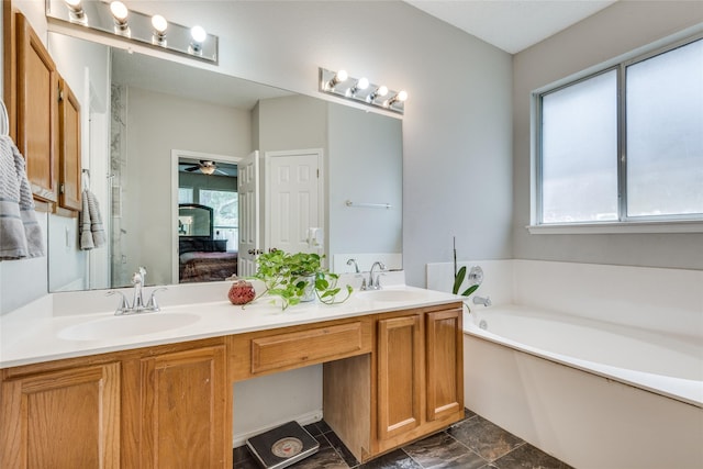 bathroom with ceiling fan, vanity, and a bath