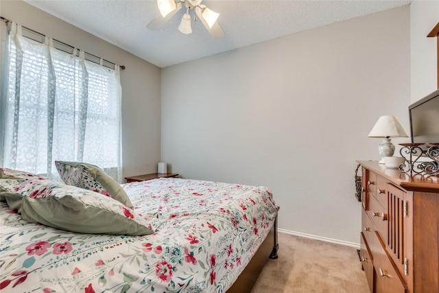 carpeted bedroom with a textured ceiling and ceiling fan