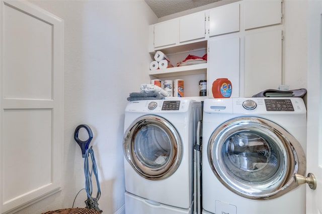 laundry room featuring cabinets, washer and dryer, and a textured ceiling