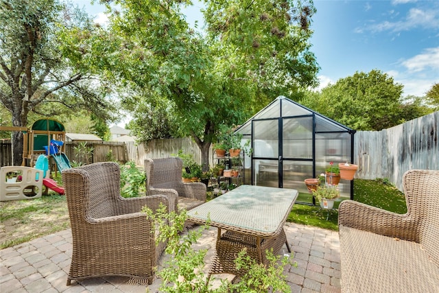 view of patio / terrace with an outdoor structure and a playground