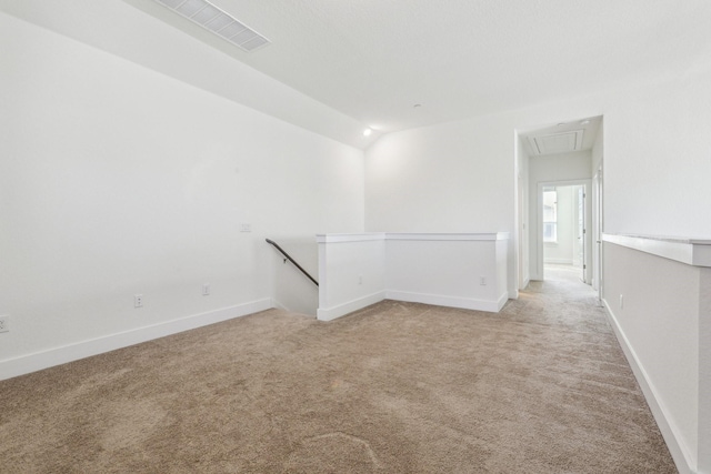 spare room with lofted ceiling and light carpet